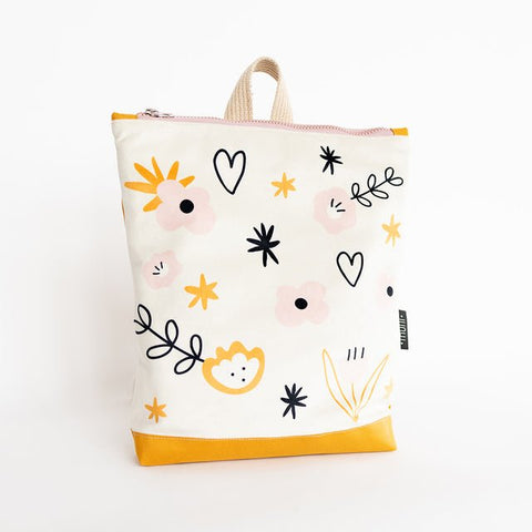 2. Kids backpack with flower design by Muni, shown in studio with yellow base