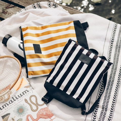 3. Muni black and white striped kids backpack with yellow striped bag in lifestyle setting