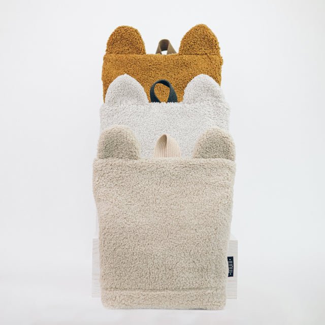 8. Three Muni teddy backpacks in different colors stacked, showing bear ears