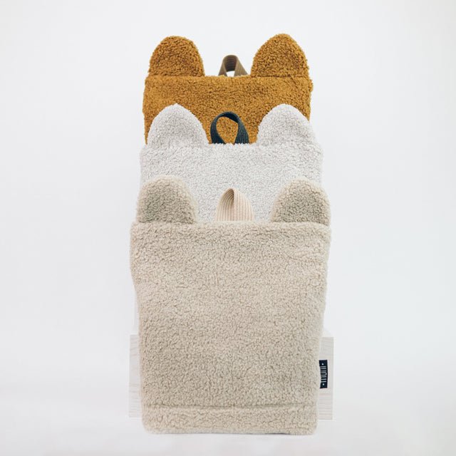 7. Studio shot of Muni teddy backpacks in brown, gray, and beige, highlighting variety and eco-friendly design