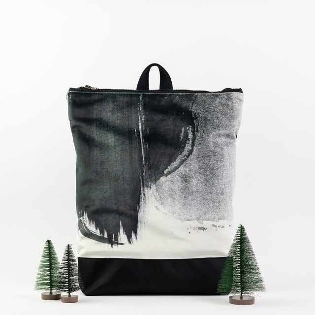 9. Muni Black Watercolor backpack in studio with decorative trees
