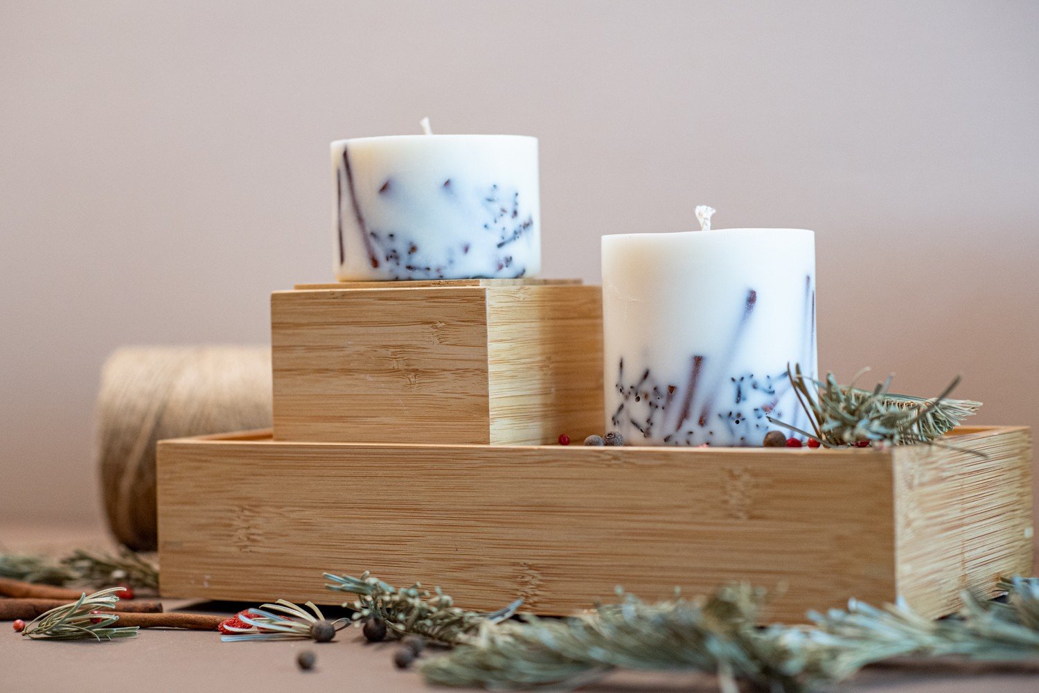 1. Hand-made soy wax candles with cinnamon sticks and cloves on wooden tray, creating a cozy atmosphere