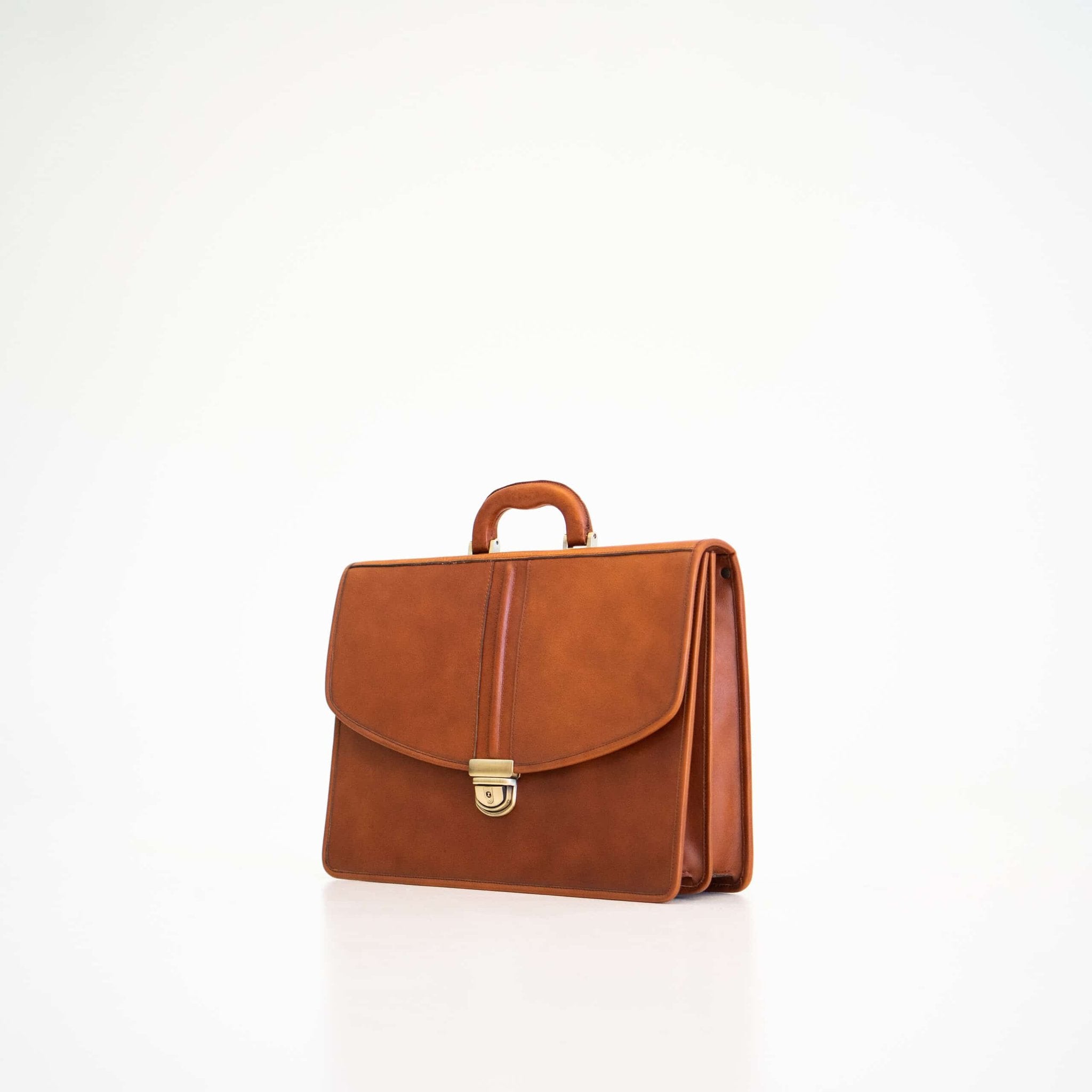 1. Papillon Leather Briefcase No. 99 in cognac, shown in studio setting with front view