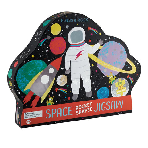1. Floss & Rock rocket-shaped jigsaw puzzle box with colorful space graphics including astronaut and planets, suitable for ages 3+, made from recycled materials