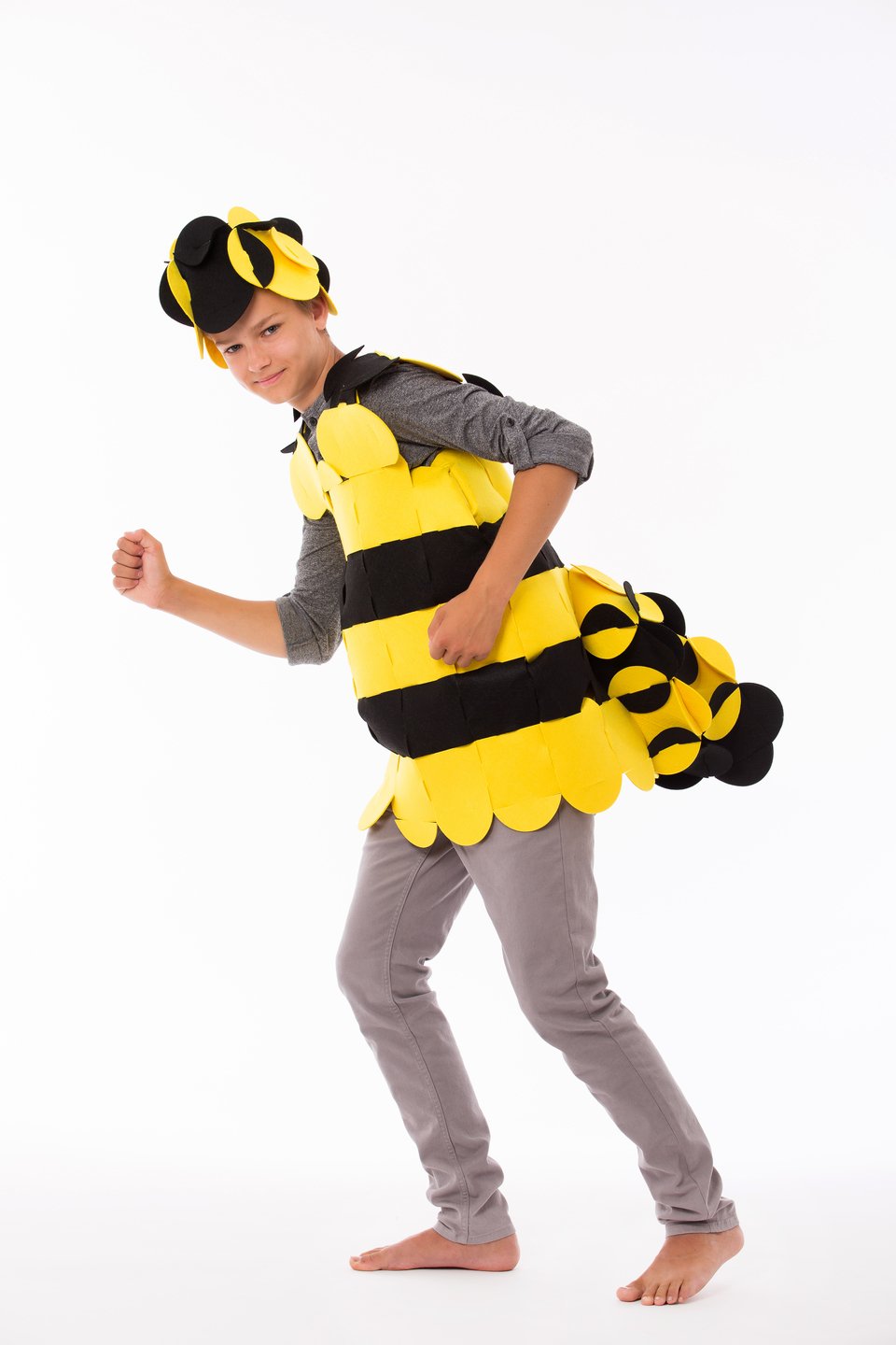2. Child in yellow and black bee costume striking a playful pose against a white background