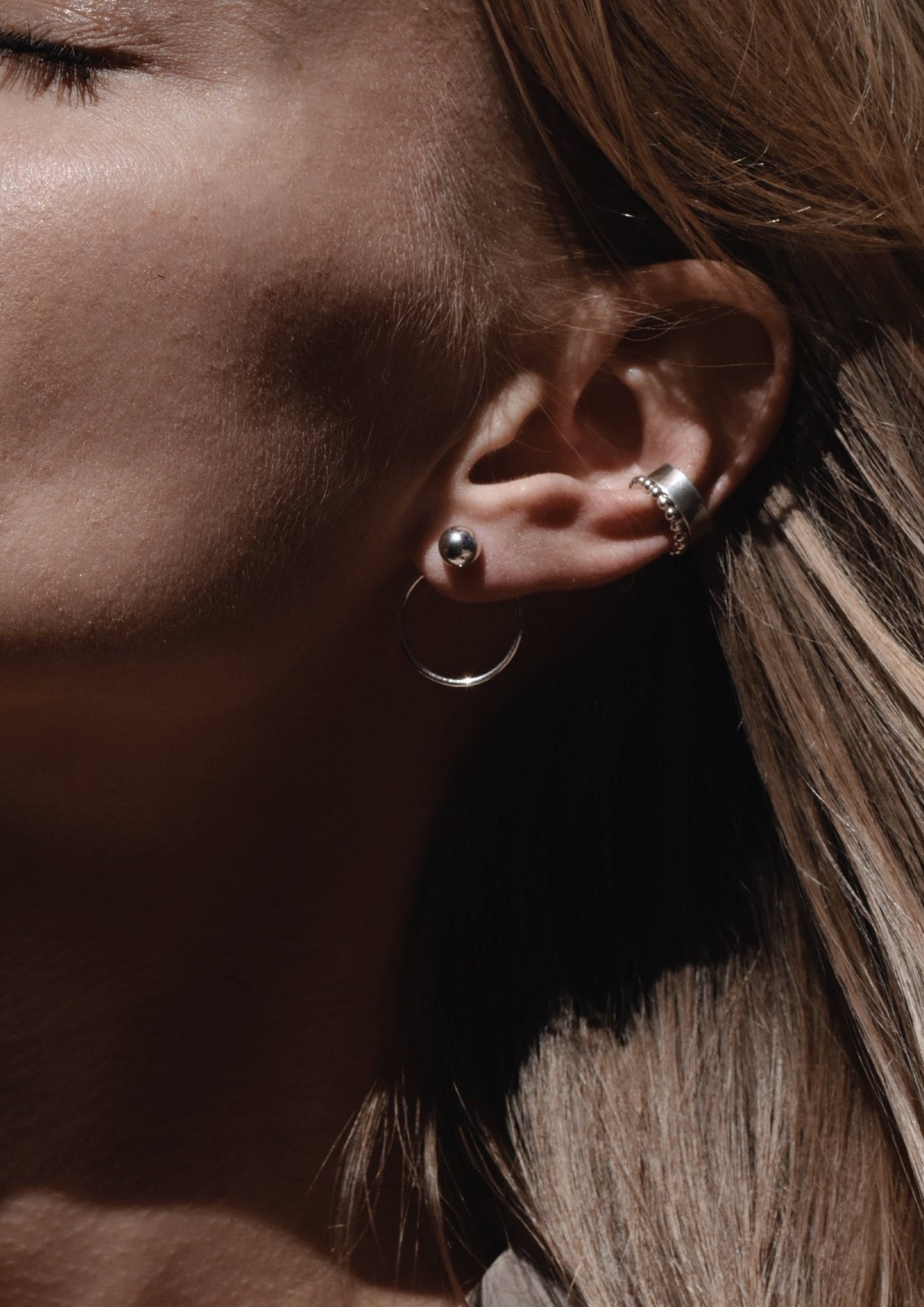 4. Close-up of NO MORE Chord Earrings in silver, showing detailed front-facing design with ball and circle