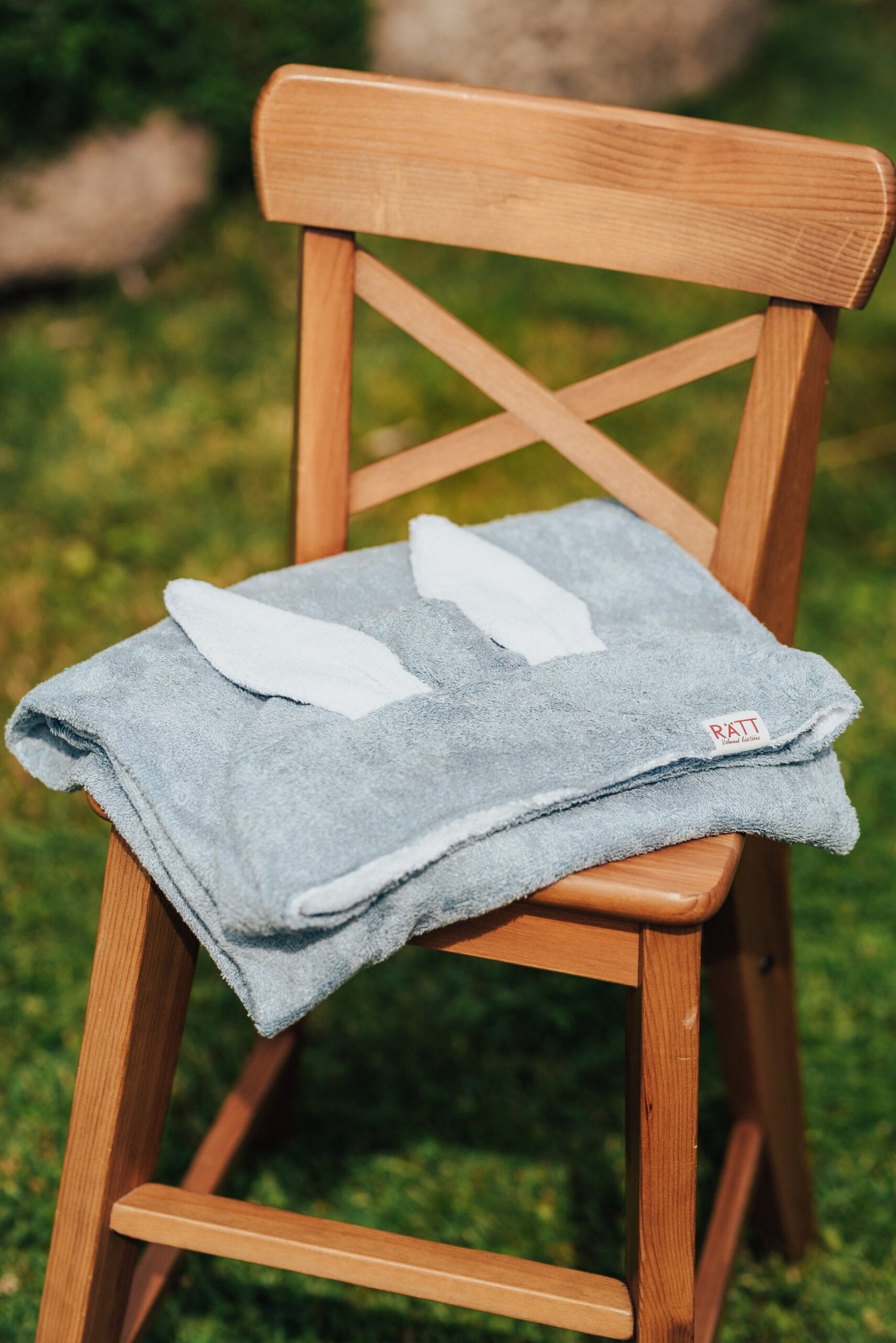 7. Blue RÄTT hooded baby bath towel with rabbit ears, folded on wooden chair