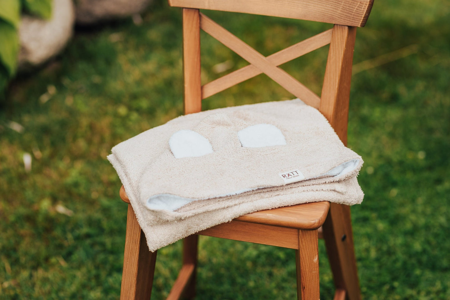 4. Beige RÄTT hooded baby bath towel with rabbit ears, folded on wooden chair