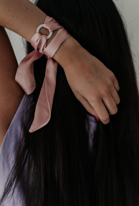 3. Woman wearing pink silk ribbon bracelet with 'SOUL SISTERS' ring, styled as a hair accessory