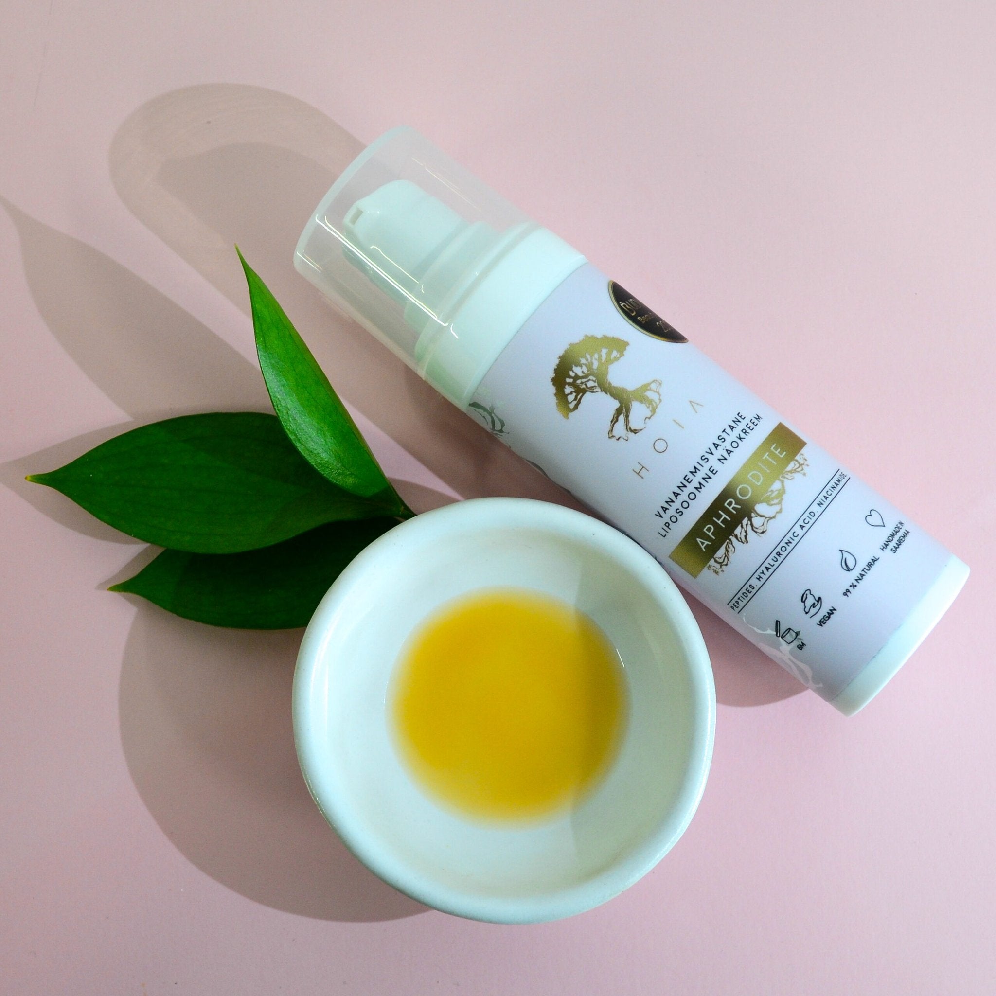 1. HOIA homespa Liposomal Face Cream Aphrodite with green leaves and cream in a bowl on a pink background