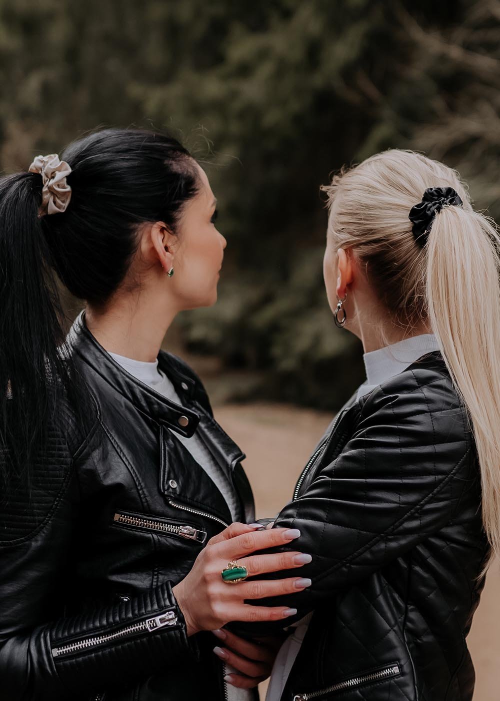 1. Women's luxury silk scrunchies in silver and black worn by models with ponytails, styled with leather jackets in outdoor setting