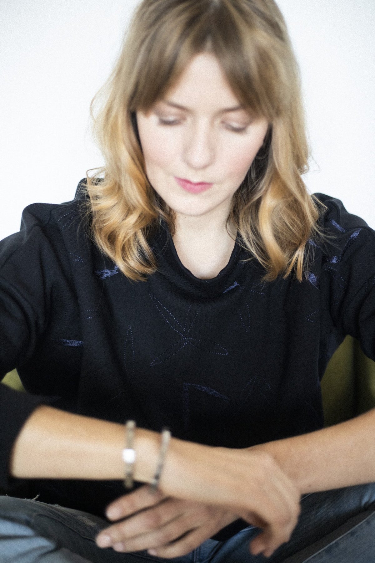 4. Woman looking at Lentsius Solis bracelet on wrist, featuring hypoallergenic stainless steel