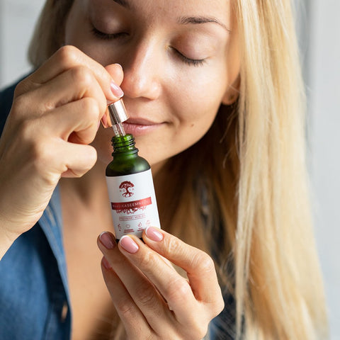 1. Woman applying HOIA homespa Strawberry Seed Oil with dropper, highlighting skincare routine