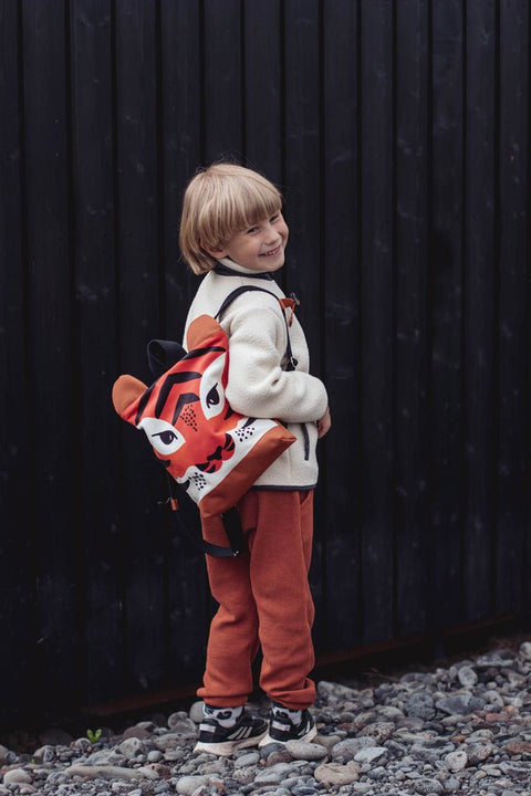 1. Child wearing Muni Tiger backpack outdoors, showcasing playful tiger design and adjustable straps