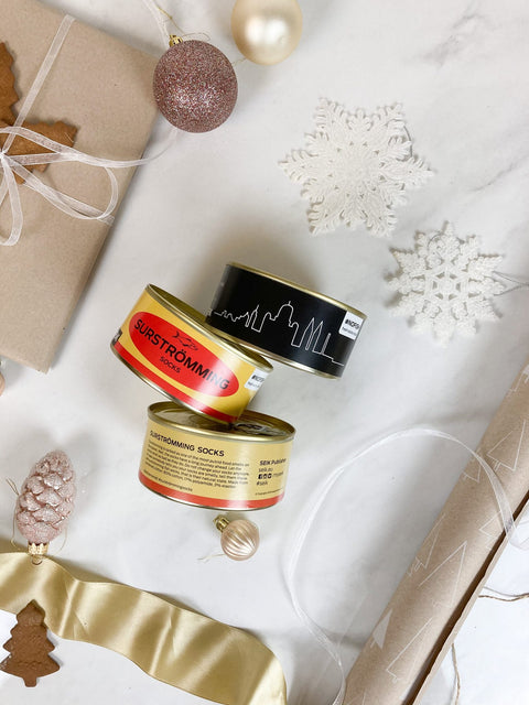 1. SEIK Socks in a Tin Can Gift Set for men and women, featuring Surstrƶmming and Tallinn designs, displayed with festive decorations