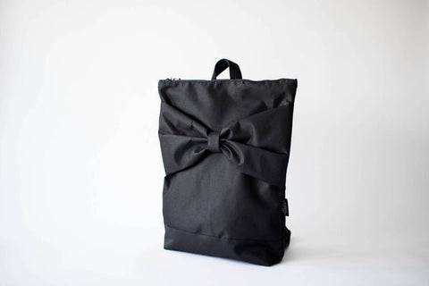 3. Studio image of Muni Black Bow Large waterproof backpack, featuring large bow design and zipper closure