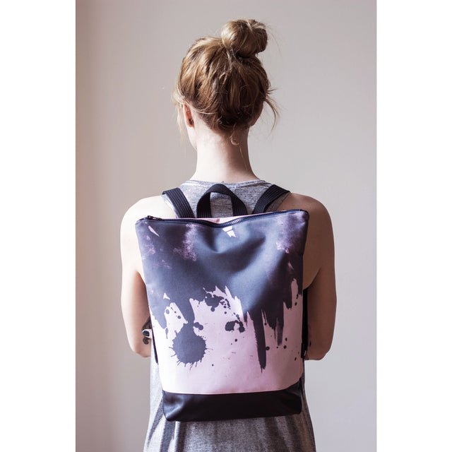 2. Woman wearing Muni Watercolor backpack in pink, shown from the back