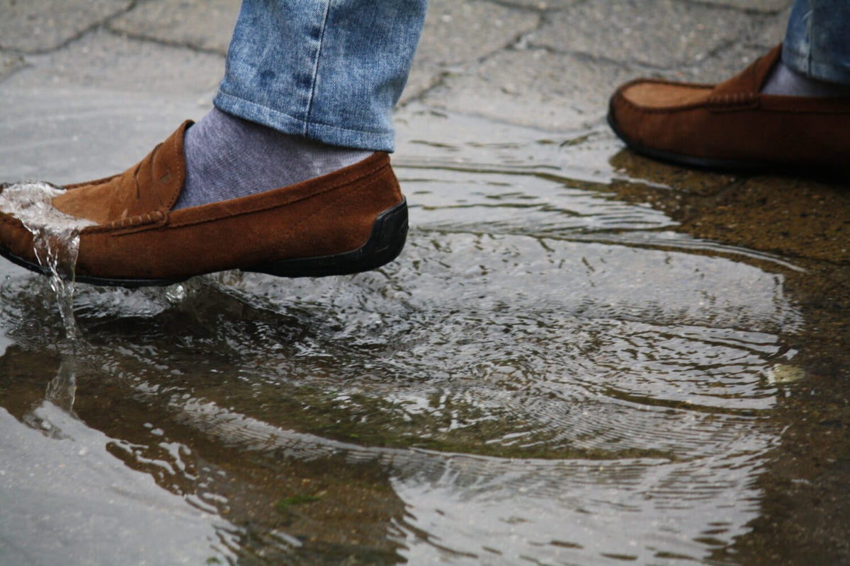 2. Brown leather shoes repelling water in puddle, showcasing GoGoNano Stay Dry Nano Coating Spray waterproof protection