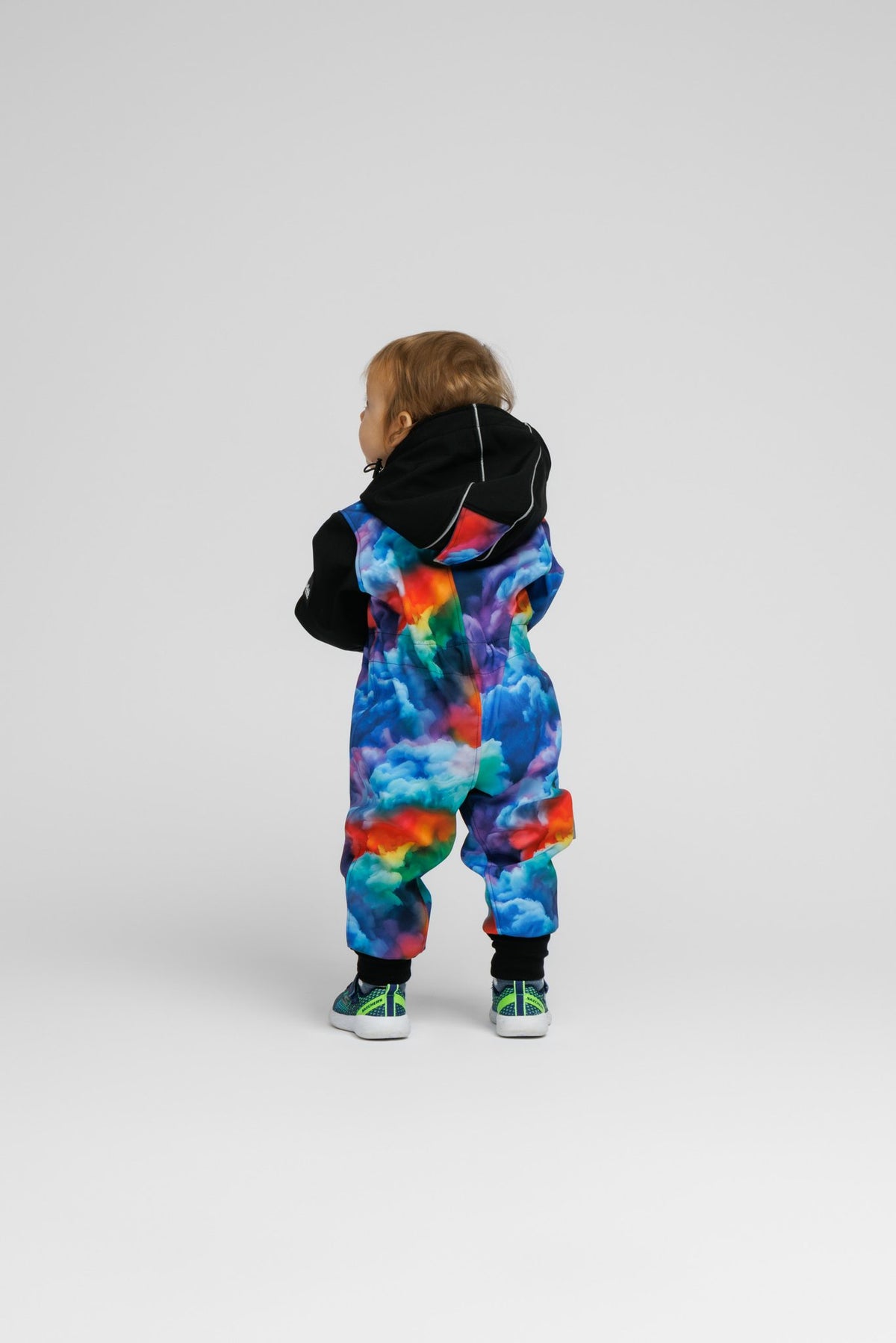 7. Toddler in colorful softshell onesie with black hood, shown from back on white background