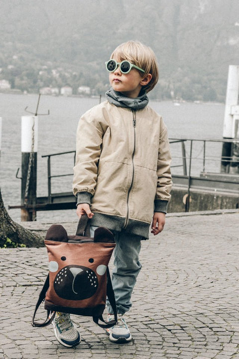2. Child running with Muni Green Bear Backpack, highlighting fun and practical design
