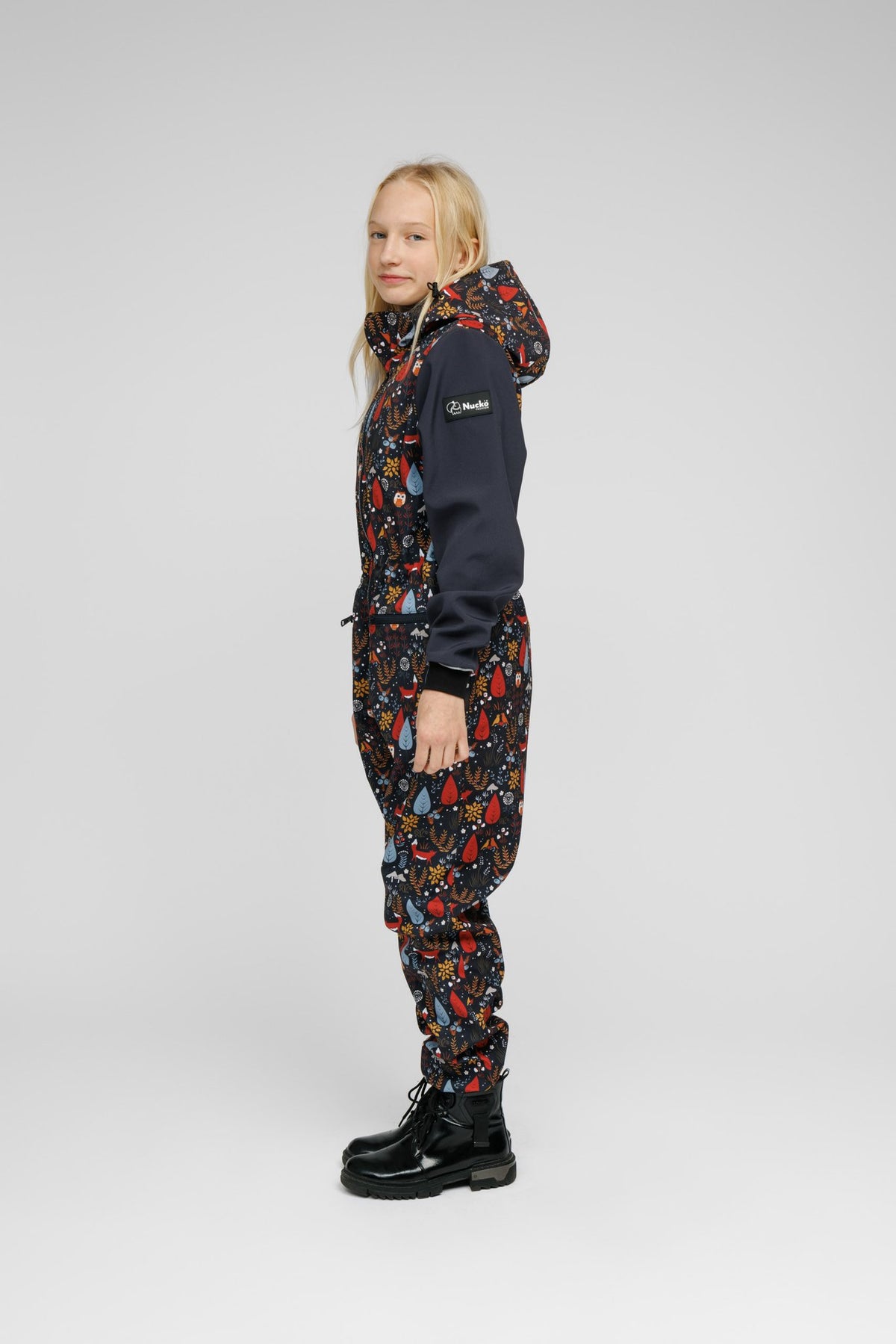 9. Child in Nuckö softshell onesie with forest print, side profile in studio