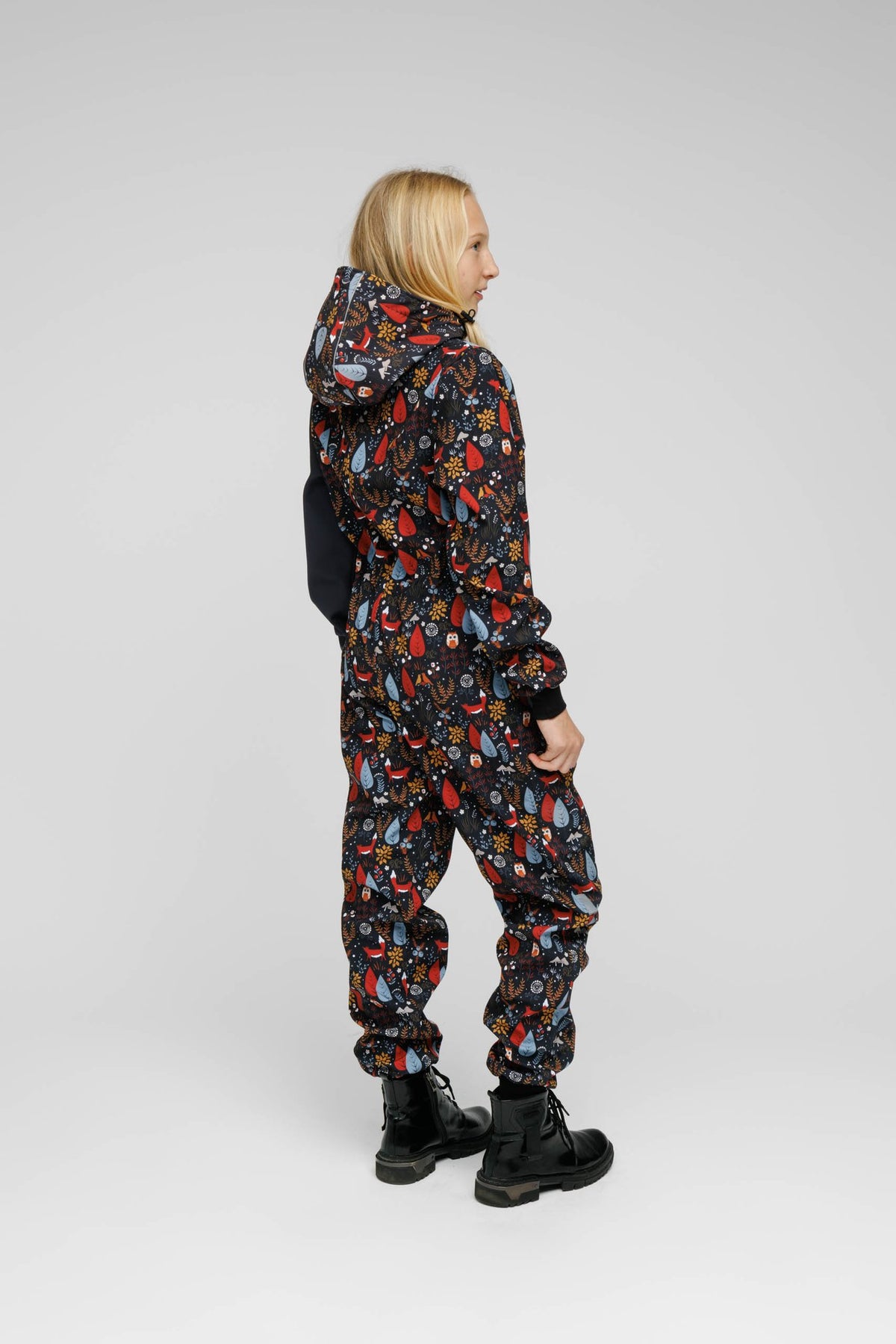 7. Child in Nuckö softshell onesie with forest print, side view in studio