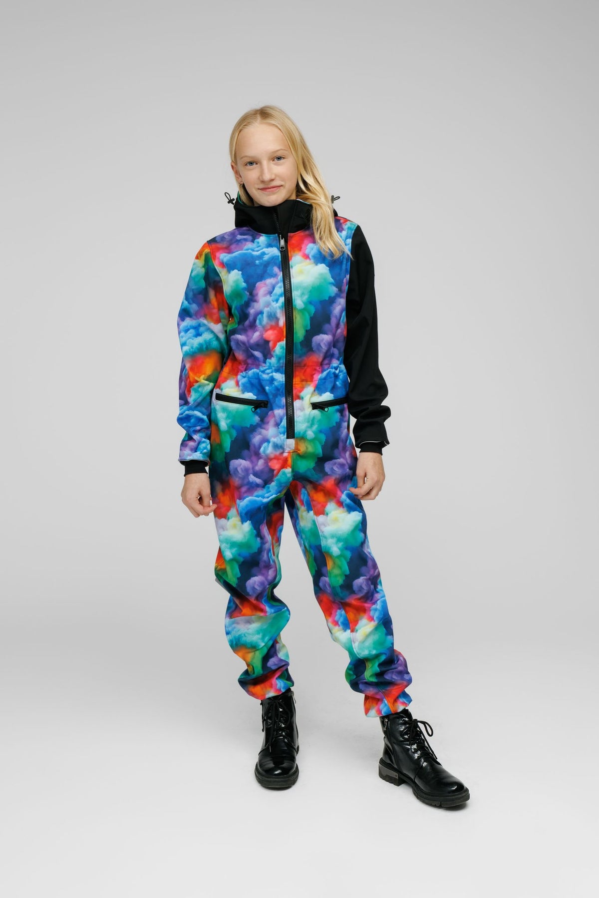 2. Child wearing vibrant softshell onesie with black sleeves and hood, standing confidently on white background