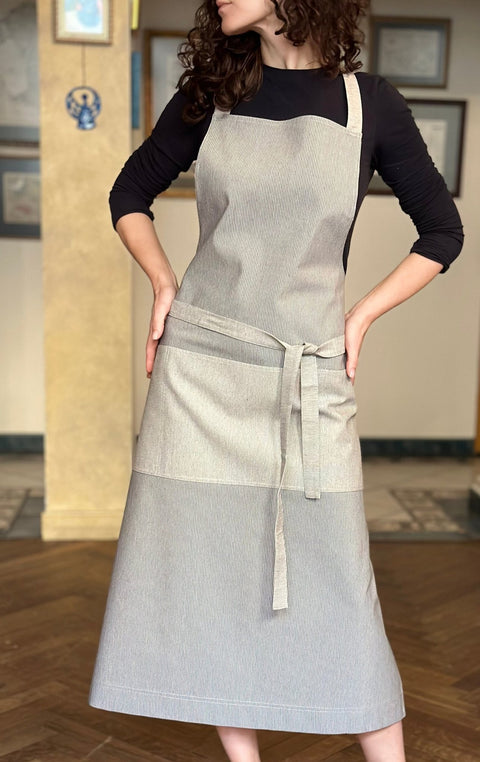 1. Woman wearing Hortensias Home Nord 2 unisex apron in Scandinavian style, showcasing recycled fabric and multiple pockets, lifestyle setting