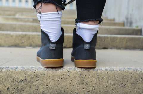 2. Back view of unisex TOKU Stockholm Sneakers on steps, highlighting design and rubber soles