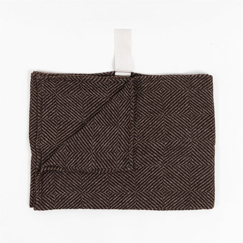 2. Folded brown linen towel with checkered fishbone pattern and white cotton hanger on white background