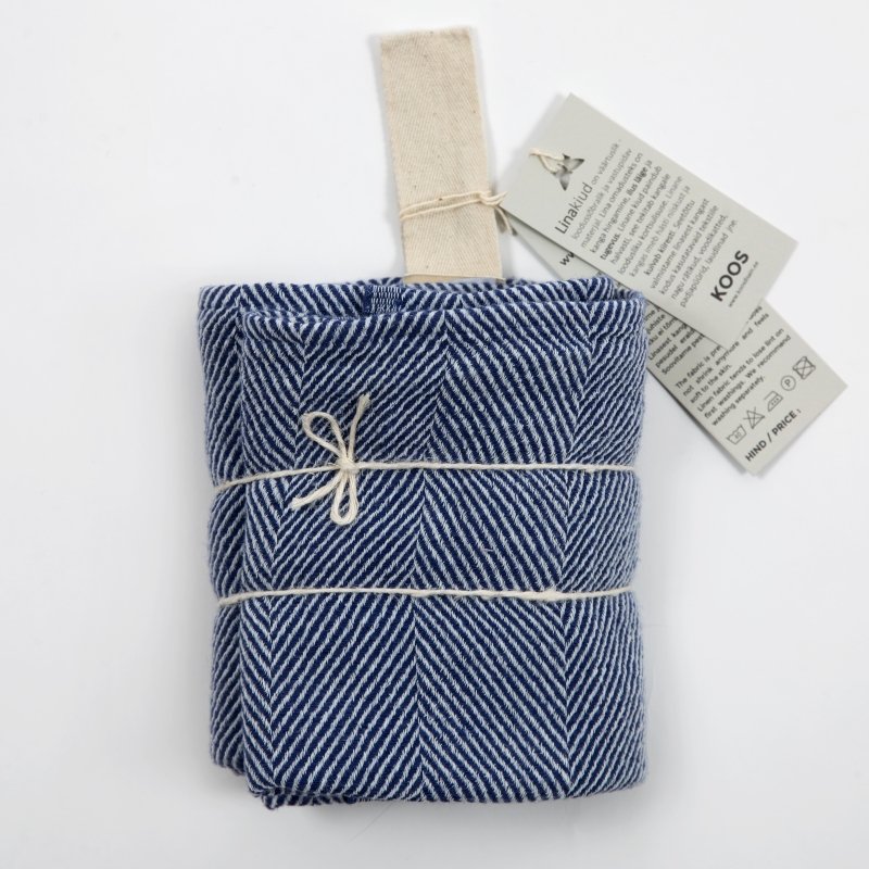 1. Folded blue linen towel with fishbone pattern and natural white hanger, tied with string, on white background