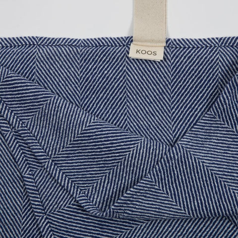 4. Close-up of blue fishbone pattern on linen towel with KOOS label and white hanger