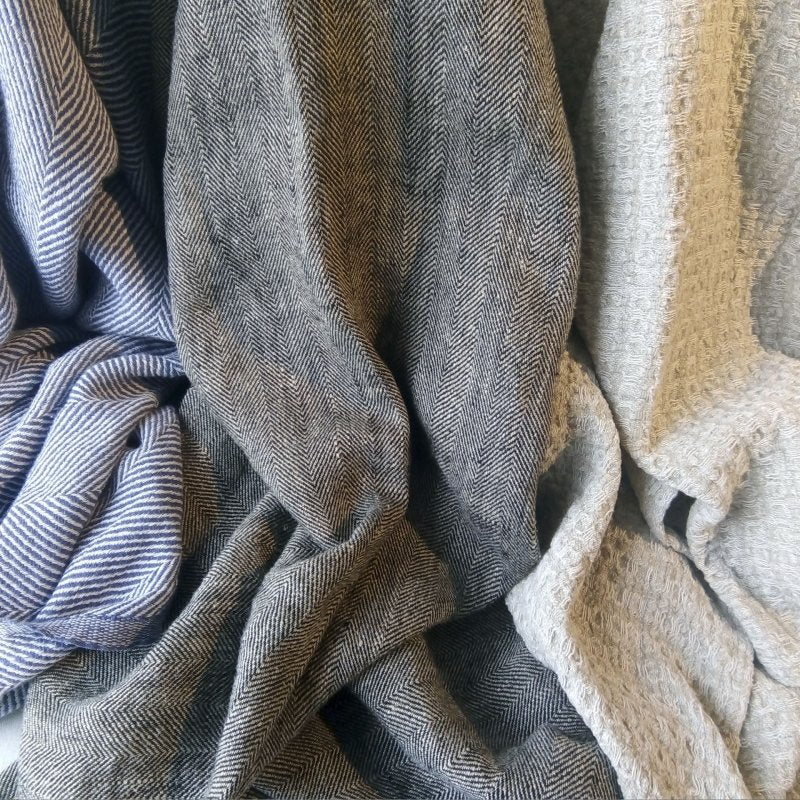 9. Draped linen towels in blue, grey, and beige showing texture and pattern