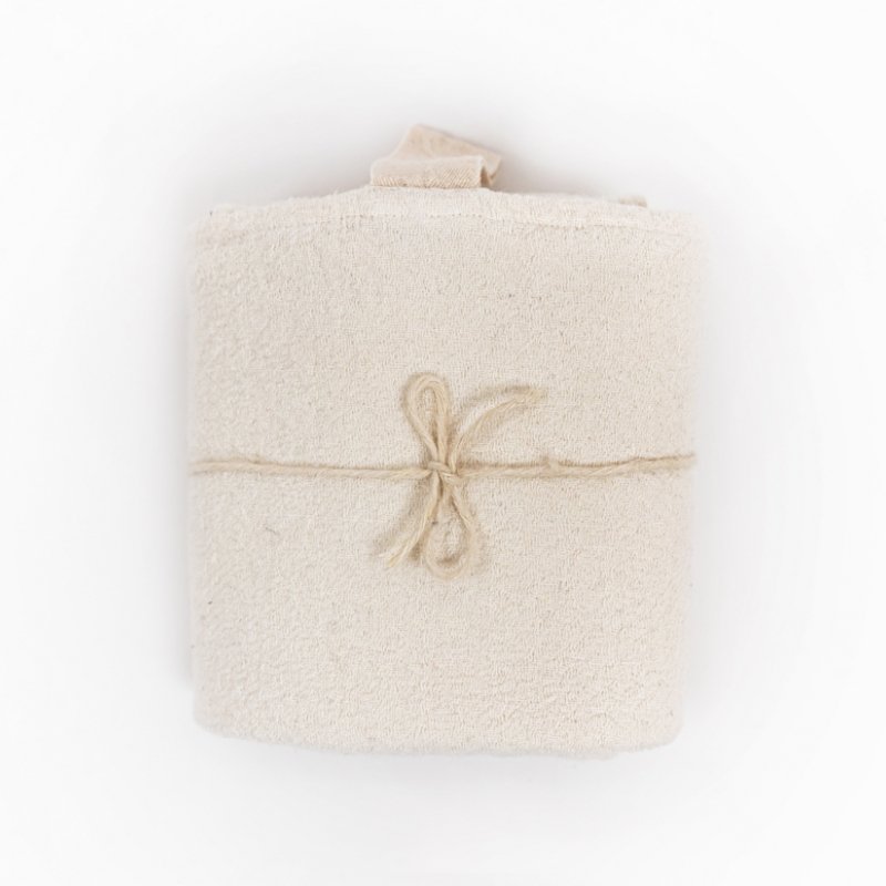 4. Rolled white linen towel with fishbone pattern tied with string, showing compact and portable design