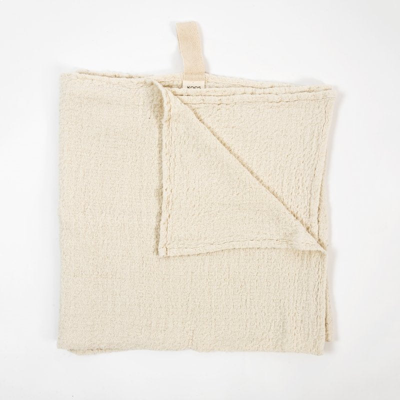 1. Flat lay of KOOSdisain big linen towel in textured white fabric with a visible cotton hanger