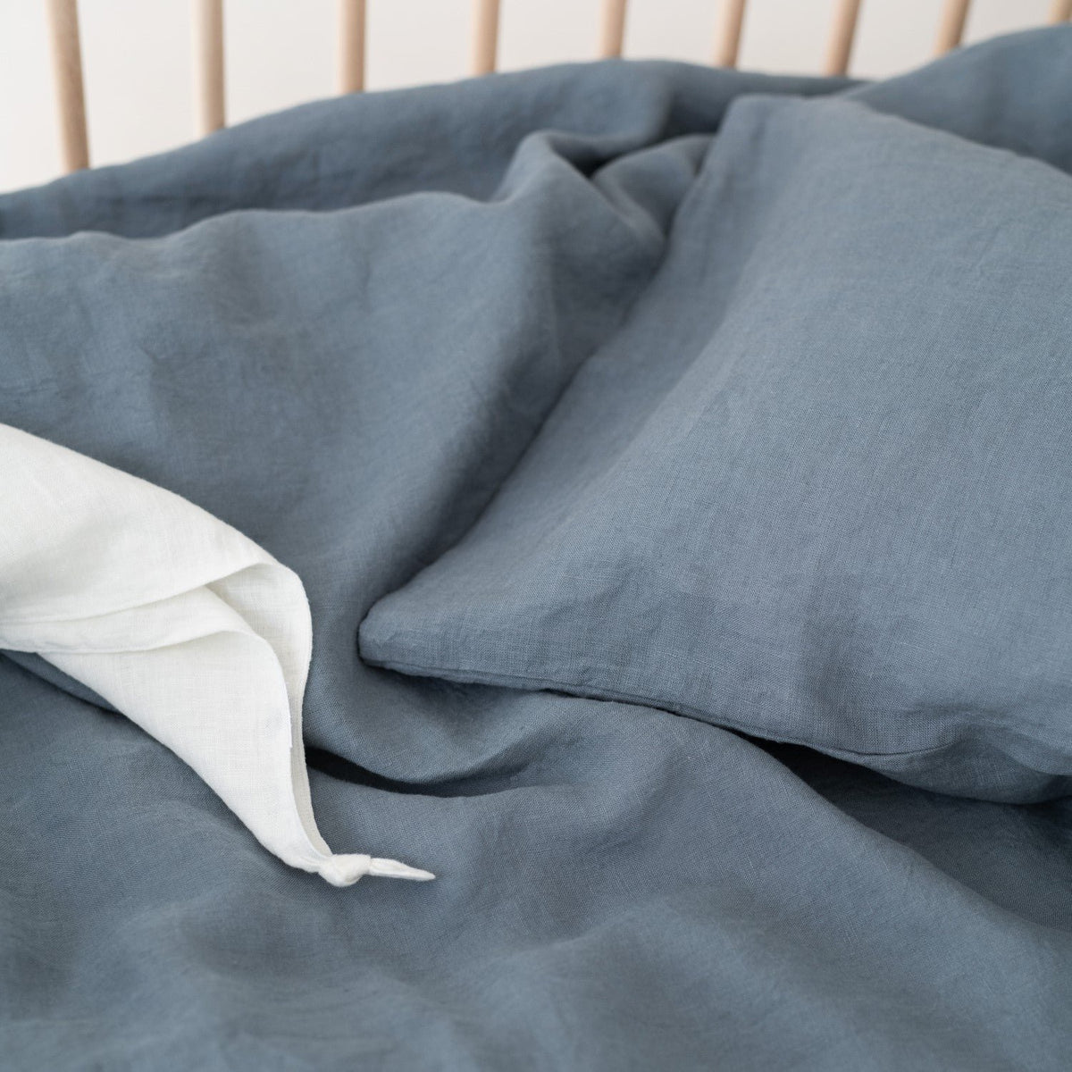 3. Close-up of blue fog linen duvet cover and pillow, highlighting fabric texture and stitching