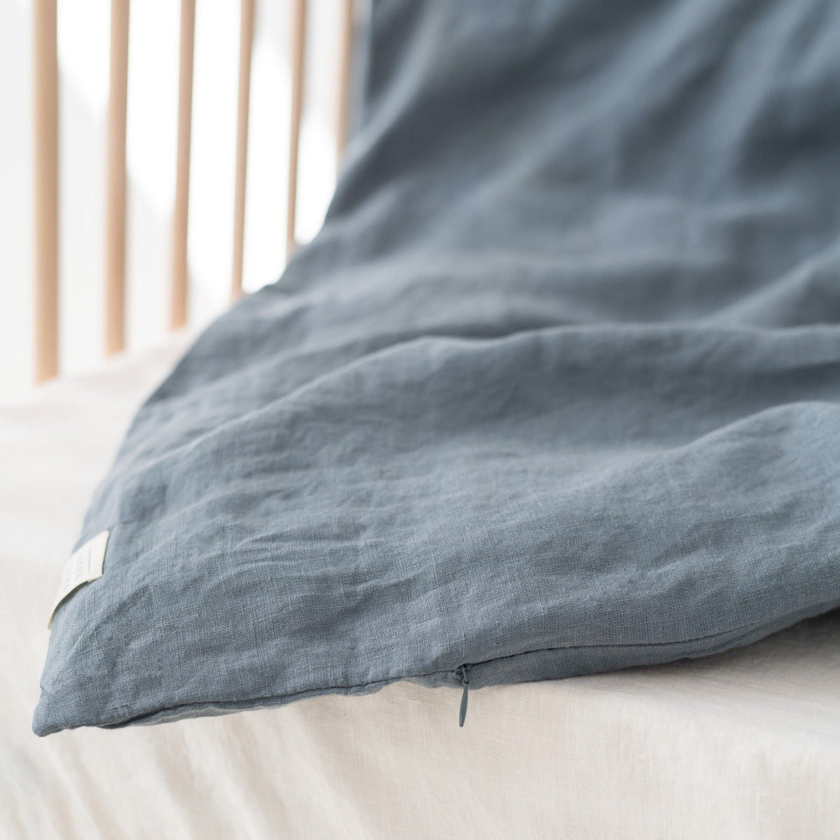 3. Detail of blue fog linen duvet cover edge, showing fabric texture and stitching