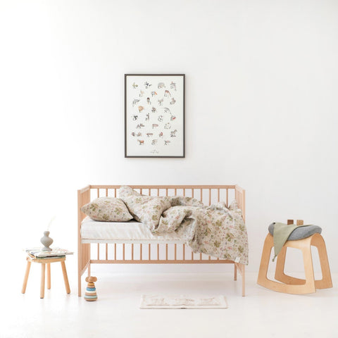 1. Kids' room with botanical print linen duvet cover set on bed, wooden crib, and decor