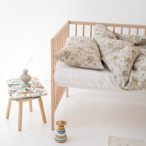 1. Kids' bed with botanical print linen duvet cover set, wooden crib, and decor in bright room