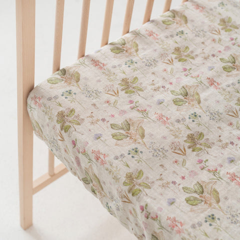 3. Close-up of kids sage linen fitted sheet with floral print on crib mattress
