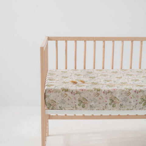2. Floral linen fitted sheet on crib mattress with light wooden crib frame