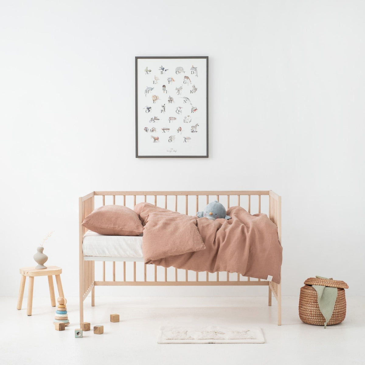 2. Kids' crib with cafe creme linen duvet cover and pillowcase, wooden toys and decor in bright room