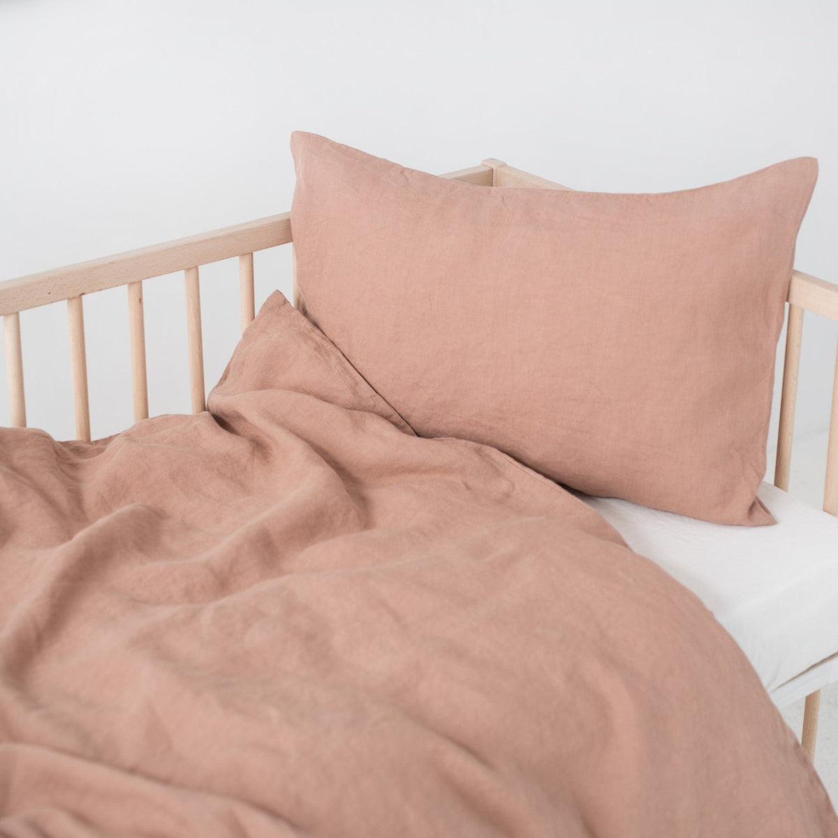 9. Cafe creme linen duvet cover and pillowcase on crib, showing soft texture and natural drape