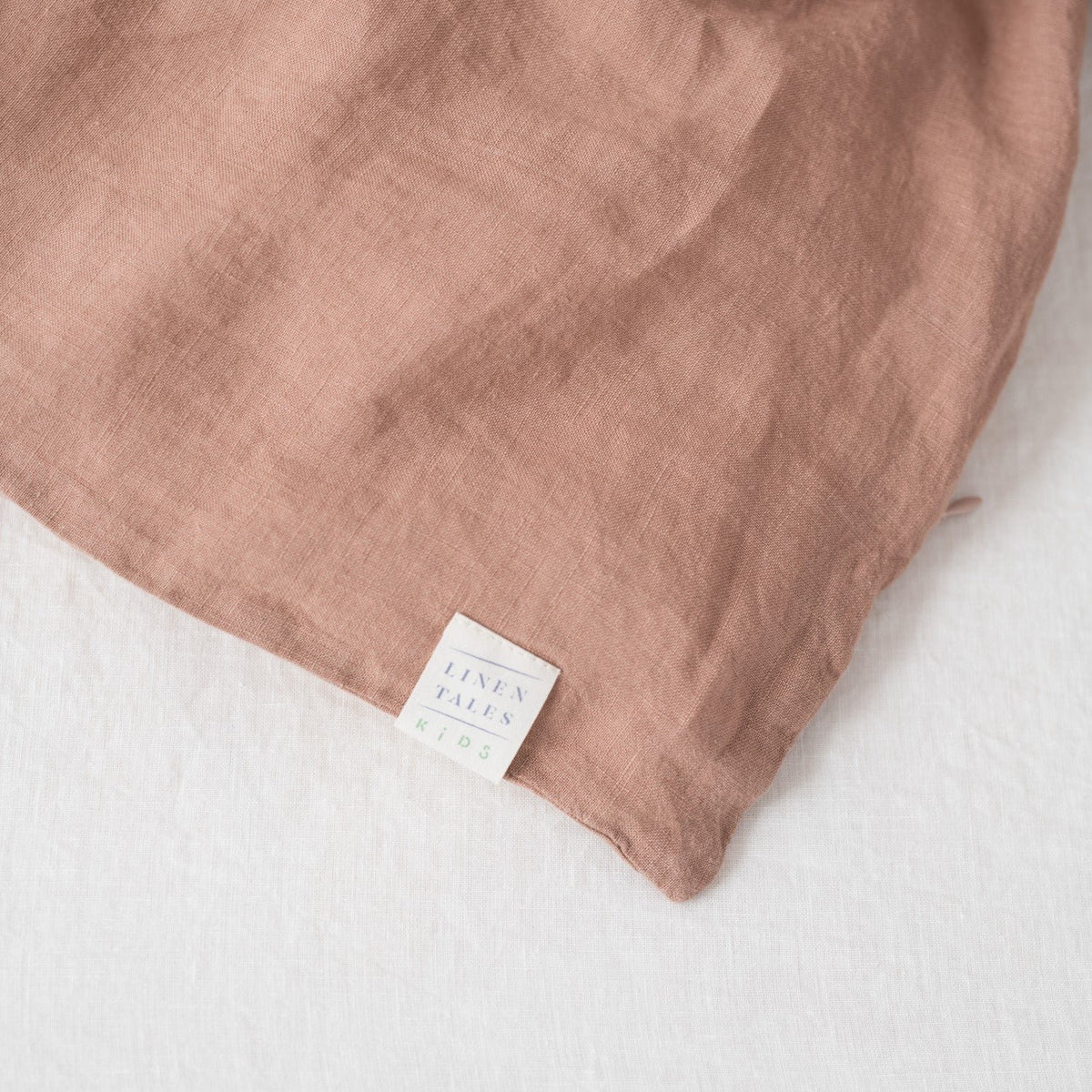 5. Close-up of Linen Tales brand tag on cafe creme linen fabric