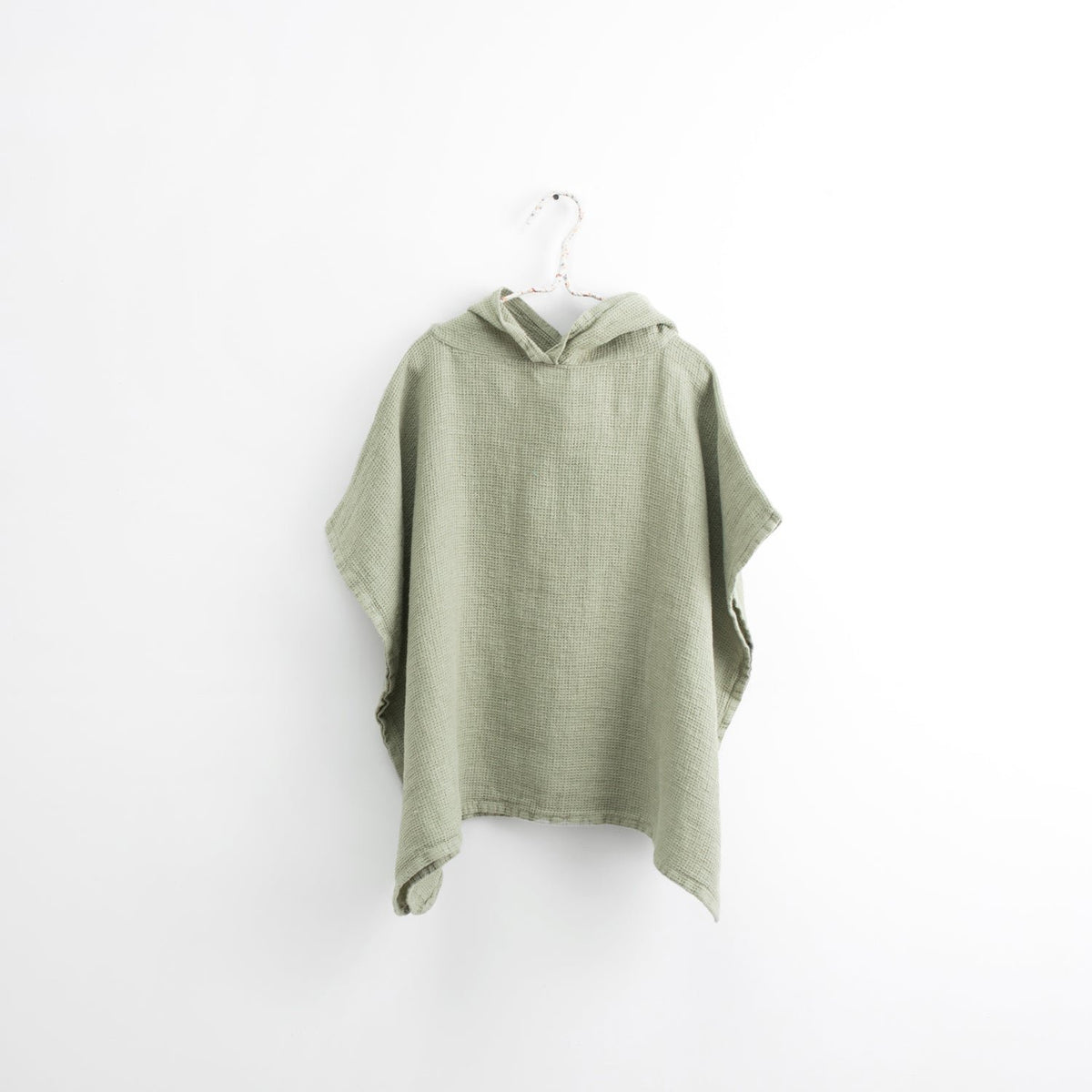2. Kids' sage green linen poncho with hood on white background, showcasing fine waffle texture