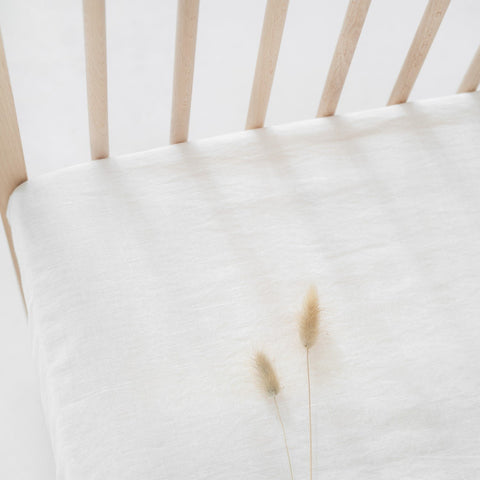 2. Close-up of white linen fitted sheet on crib, highlighting the fabric texture and natural fibers