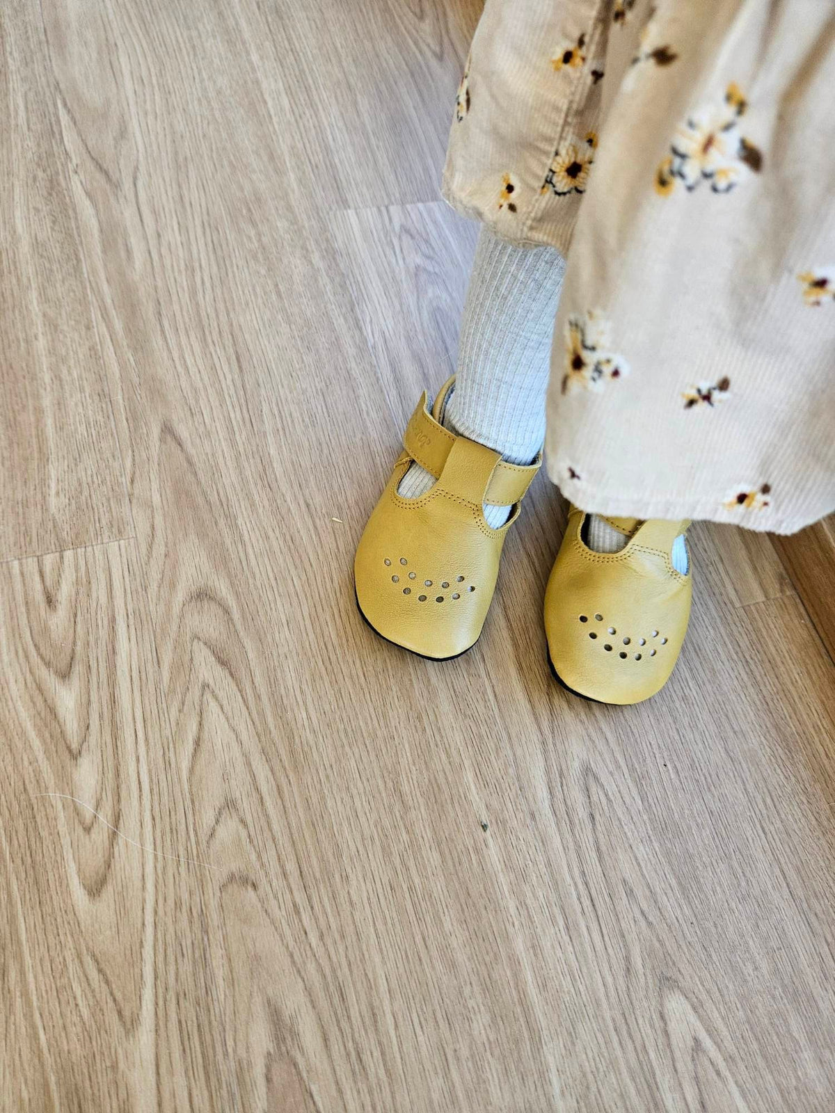 3. Close-up of Omaking yellow Mutsu slippers on child's feet, showing adjustable Velcro fastener