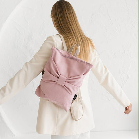4. Woman wearing Muni Pink Bow backpack, showing adjustable straps and bow detail