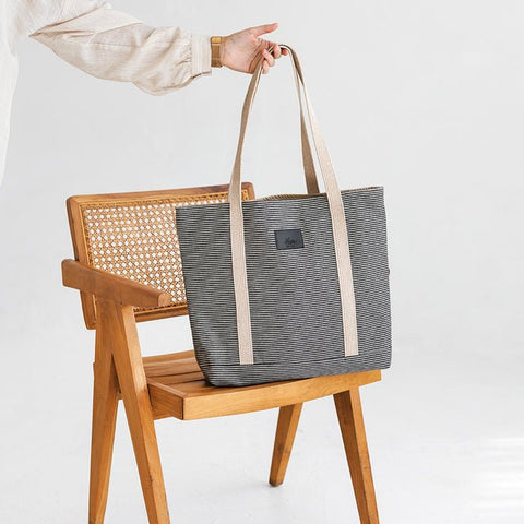 2. Muni striped denim tote bag placed on wooden chair in studio