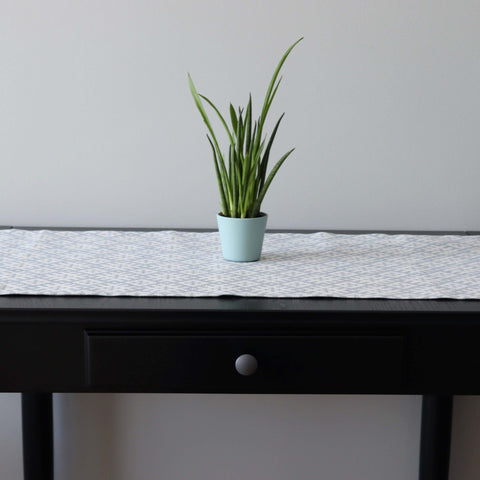 1. Table runner with Setumaa folk art pattern on black table with potted plant, 145 x 40 cm, linen-cotton blend